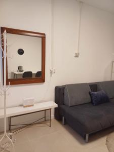 ein Wohnzimmer mit einem Sofa und einem Spiegel in der Unterkunft סטודיו איתמר in Tel Aviv