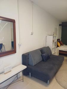 a living room with a couch and a mirror at סטודיו איתמר in Tel Aviv