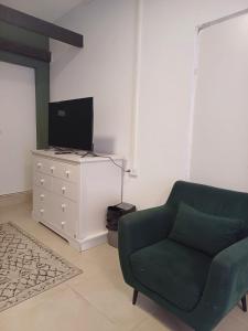 a living room with a green couch and a tv at סטודיו איתמר in Tel Aviv