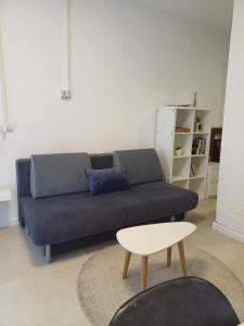 ein Wohnzimmer mit einem blauen Sofa und einem Tisch in der Unterkunft סטודיו איתמר in Tel Aviv