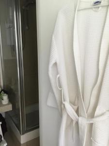 a white robe hanging on a door in a bathroom at THE HIDEAWAY - KENT in Sole Street