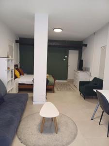 ein Wohnzimmer mit einem Sofa und einem Tisch in der Unterkunft סטודיו איתמר in Tel Aviv