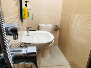 a bathroom with a white sink and a toilet at Sethumka Ayurveda & Yoga Resort in Wadduwa