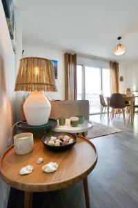 uma sala de estar com uma mesa com uma tigela de pedras em Les sables blancs*50m de la mer* em Concarneau