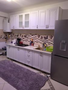 a kitchen with white cabinets and a black refrigerator at Casa de inchiriat in Vaslui in Vaslui