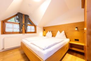 a bedroom with a large white bed with a window at Villa Agricola in Kaprun