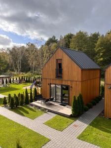 une grange en bois avec une terrasse dans un jardin dans l'établissement MikroKlimat, à Jarosławiec