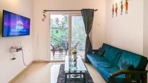 uma sala de estar com um sofá verde e uma mesa de vidro em Poolside Paradise 1Bhk Luxury Apartment in Siolim. em Siolim