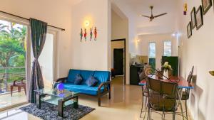 a living room with a blue couch and a table at Poolside Paradise 1Bhk Luxury Apartment in Siolim. in Siolim