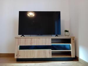 uma televisão de ecrã plano num centro de entretenimento em madeira em Apartament Na Wzgórzach em Rymanów