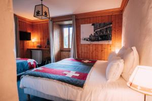 a bedroom with a bed with a cross blanket on it at Chalet-hôtel Gai Soleil in Les Contamines-Montjoie