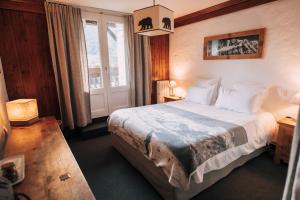 een slaapkamer met een bed en een raam bij Chalet-hôtel Gai Soleil in Les Contamines-Montjoie