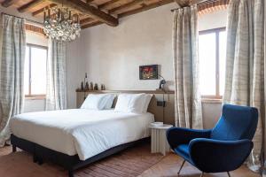 1 dormitorio con 1 cama, lámpara de araña y 2 sillas en Paradis Agricole en Pietrasanta