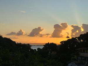 un coucher de soleil sur une étendue d'eau plantée d'arbres dans l'établissement Refugio Do Morro - Morro São Paulo, à Morro de São Paulo