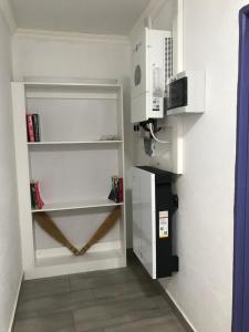 a small kitchen with a microwave and a shelf at The Affectionate One in Louis Trichardt