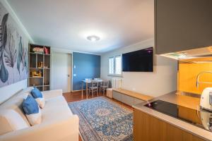 a living room with a white couch and a kitchen at Royal Suite Parma con Piscine Calda e Fredda in Parma