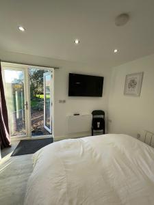 a bedroom with a bed and a flat screen tv at Riverside Annex at Ashbank in Penrith