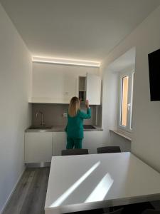 Una mujer parada en una cocina en una habitación en Rosso Conero - Le Grotte Rooms & Apartments, en Camerano