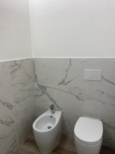 y baño con aseo blanco y lavamanos. en Rosso Conero - Le Grotte Rooms & Apartments, en Camerano