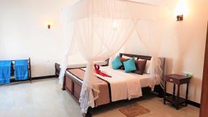 1 dormitorio con 1 cama con dosel en Tropical Inn, en Mirissa
