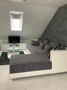 a living room with a couch and a tv at Herz der Weinberge in Gemmrigheim