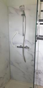 een douche met een douchekop in de badkamer bij Maison chaleureuse in Casseneuil