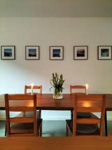 uma mesa de madeira com cadeiras e um vaso de flores em Sea la vie em Oostende