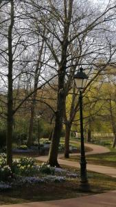 um poste de luz num parque com árvores e flores em Sea la vie em Oostende