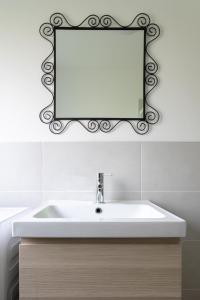 a bathroom with a white sink and a mirror at WoodenKey Asiago bicamere immerso nel verde in Asiago