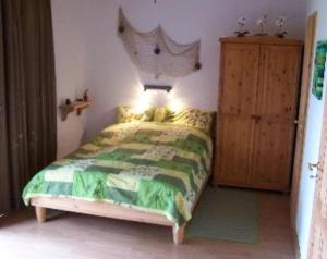 1 dormitorio con 1 cama y armario de madera en Ferienapartments Seeblick Dahmen, en Dahmen