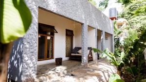 a building with a porch in a garden at Haradali's Home in Arusha