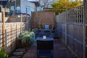 a patio with a table and chairs and a fence at The Leyton Midland Crib - Cozy 2BDR Flat with Study Room + Garden in London