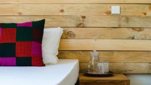 a bedroom with a bed with a wooden wall at Haradali's Home in Arusha