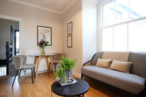 a living room with a couch and a table at The Leyton Midland Crib - Cozy 2BDR Flat with Study Room + Garden in London