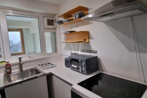a small kitchen with a microwave and a sink at Gottersea 1 bedroom flat in Battersea 70 mq in London
