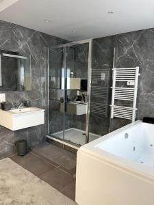 a bathroom with a shower and a tub and a sink at Savigny-le-Temple : Magnifique suite avec jacuzzi in Savigny-le-Temple