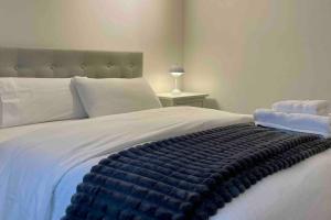Una cama con una manta azul encima. en Apartamento Entero 2 HABITACIONES, en León