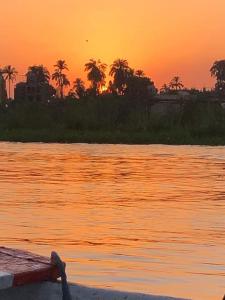 a boat on the water with a sunset in the background at Rose travel_trips in Jazīrat al ‘Awwāmīyah