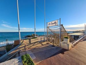 ein Schild für einen Strand mit dem Meer im Hintergrund in der Unterkunft Studio grande terrasse à 5 min de la mer in Nizza