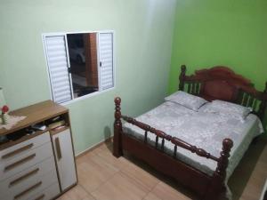 a bedroom with a bed and a dresser and a window at Estância Martins in Extrema