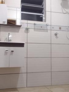 a kitchen with white cabinets and a sink at Estância Martins in Extrema