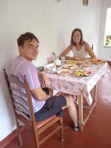 a man and a woman sitting at a table with food at Sanaya Homestay in Tangalle