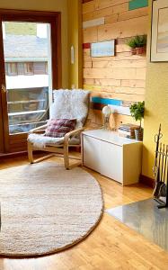 uma sala de estar com uma cadeira e uma mesa em Casa Tuca em Candanchú