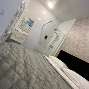 a bathroom with a shower and a bed in a room at The Residence Apeldoorn in Apeldoorn