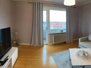 sala de estar con sofá y ventana grande en Iris en Huskvarna