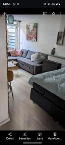- un salon avec un canapé et un lit dans l'établissement zomerhuis in Wijk aan Zee! 2 pers, à Wijk aan Zee