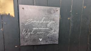 a sign on the side of a wooden wall at zomerhuis in Wijk aan Zee! 2 pers in Wijk aan Zee