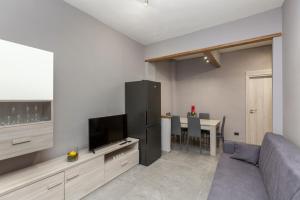 a living room with a couch and a tv and a table at Casa Venera in Turin
