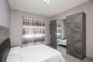 a white bedroom with a bed and a mirror at Casa Venera in Turin