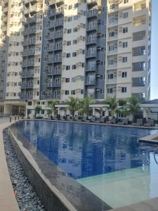 a swimming pool in front of two large apartment buildings at Hector's Place at SMDC Vine Residences in Manila